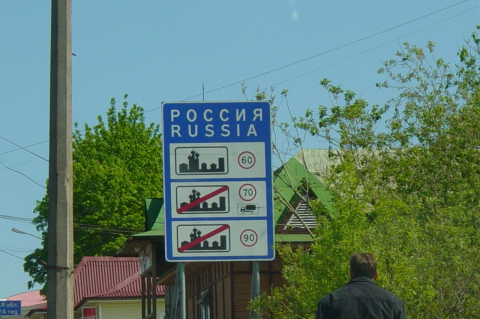 Синий щит с ограничениями скорости в городе и на трассе у въезда в страну 