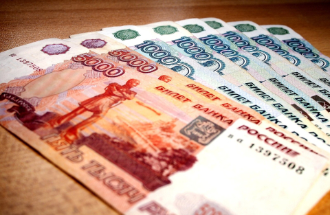 Веер российских банкнот номиналом в пять и одну тысячу рублей на столе 