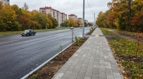 Свежеуложенная плитка тротуара и бордюр у дороги, вид с высоты 