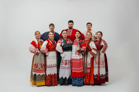 Фольклорный коллектив в народных костюмах выступает на сцене театра в Москве 