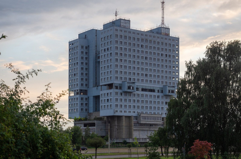 Бетонный Дом Советов среди деревьев в Калининграде на закате 
