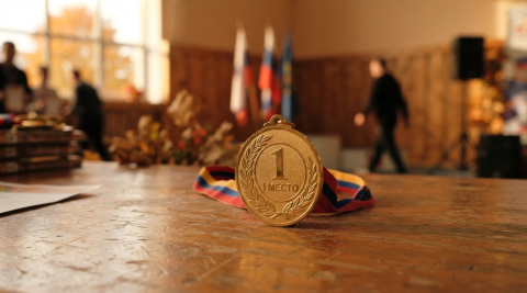 Золотая медаль за первое место стоит на ребре в тёплом золотистом свете 