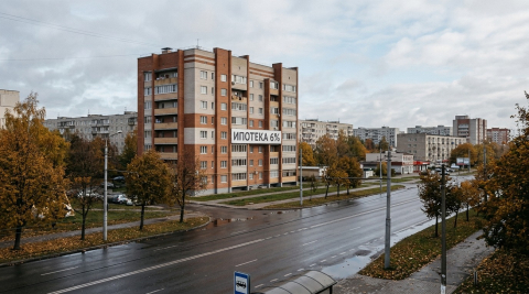 Жилой многоэтажный дом и вывеска ипотечного кредитования на фоне города в Калининградской области 