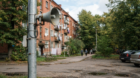 Уличный громкоговоритель системы оповещения на столбе у жилого дома 