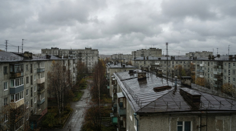 Пасмурное небо над мокрыми после дождя крышами тихого жилого квартала в Мурманске 