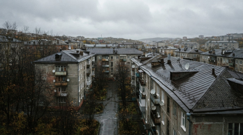 Пасмурное небо над мокрыми после дождя крышами тихого жилого квартала в Мурманске 