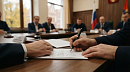 Руки подписывают документ ручкой на столе во время официальной встречи 
